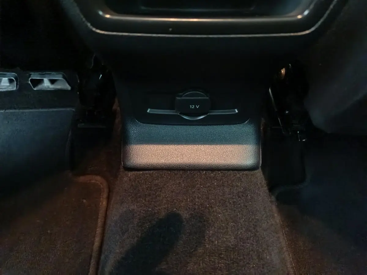 Prise 12V noire en bas de la console centrale, vue rapprochée de l'intérieur du Skoda Karoq 2024.