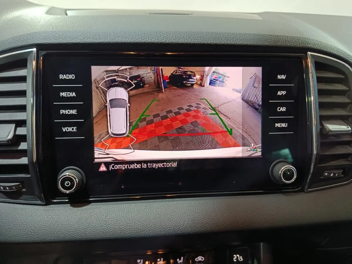 Écran tactile central montrant la caméra de recul avec trajectoire assistée dans un Skoda Karoq 2024 gris.