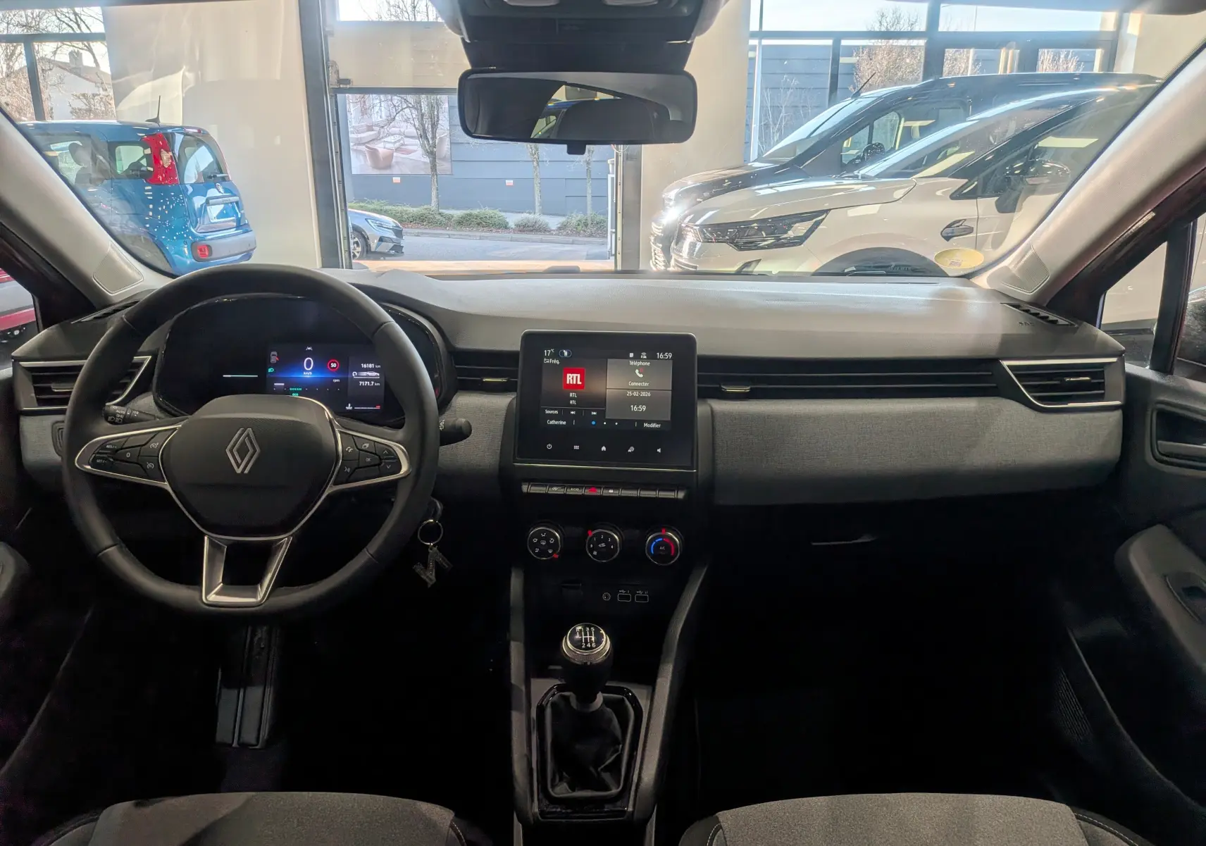 Vue intérieure avant de la Renault Clio V Orange Valencia, tableau de bord avec écran tactile et boîte manuelle.