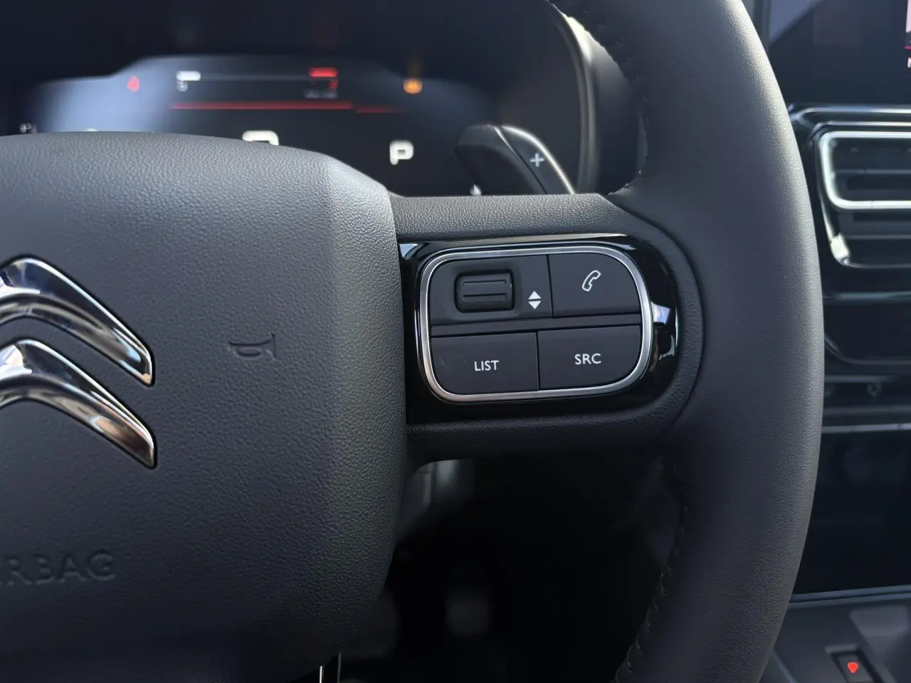Gros plan sur la partie droite du volant noir du Citroën C5 Aircross 2025 avec commandes intégrées et logo chromé.