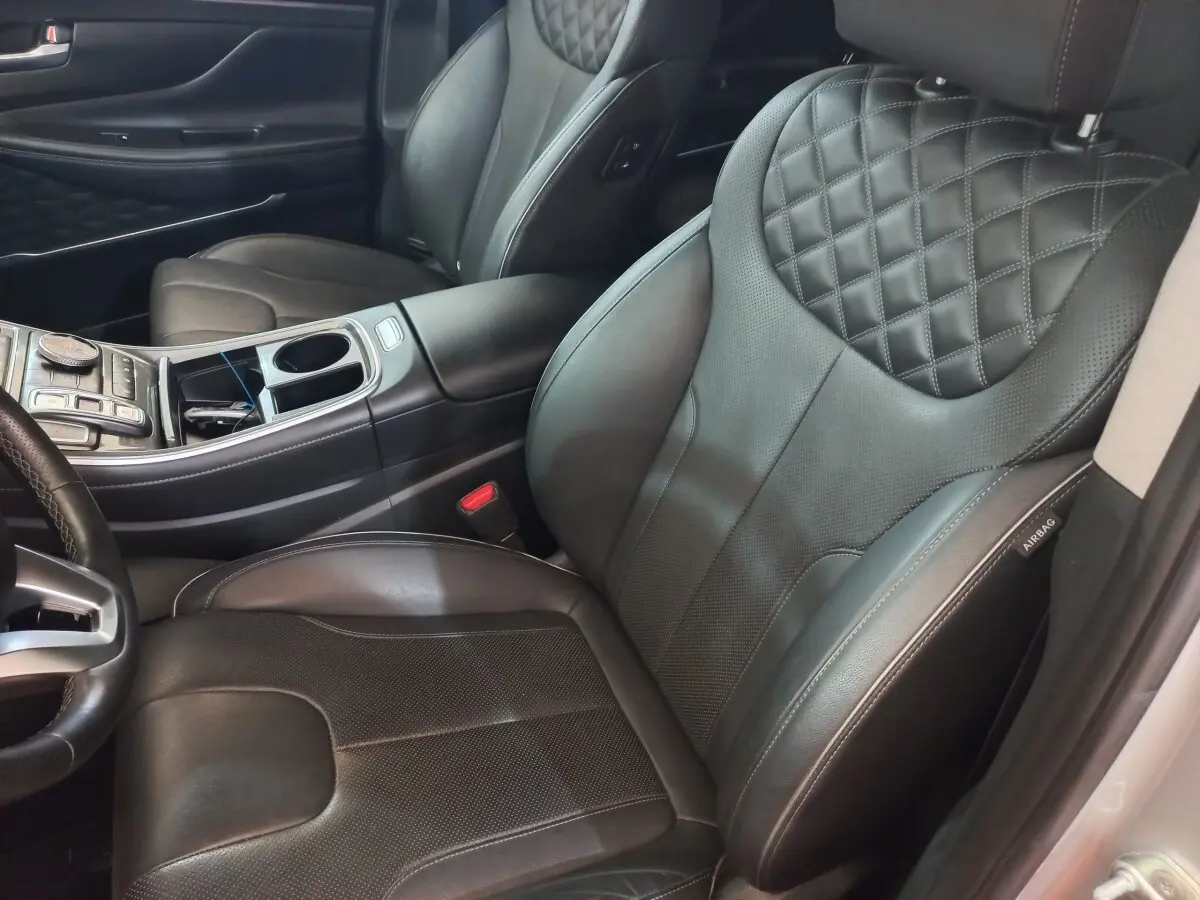 Vue intérieure côté droit montrant les sièges avant en cuir noir matelassé du Hyundai Santa Fe hybride rechargeable 2021.