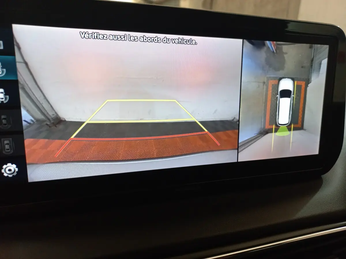 Vue écran caméra 360° du Hyundai Santa Fe hybride, affichant l’arrière et la vue aérienne du véhicule en stationnement.