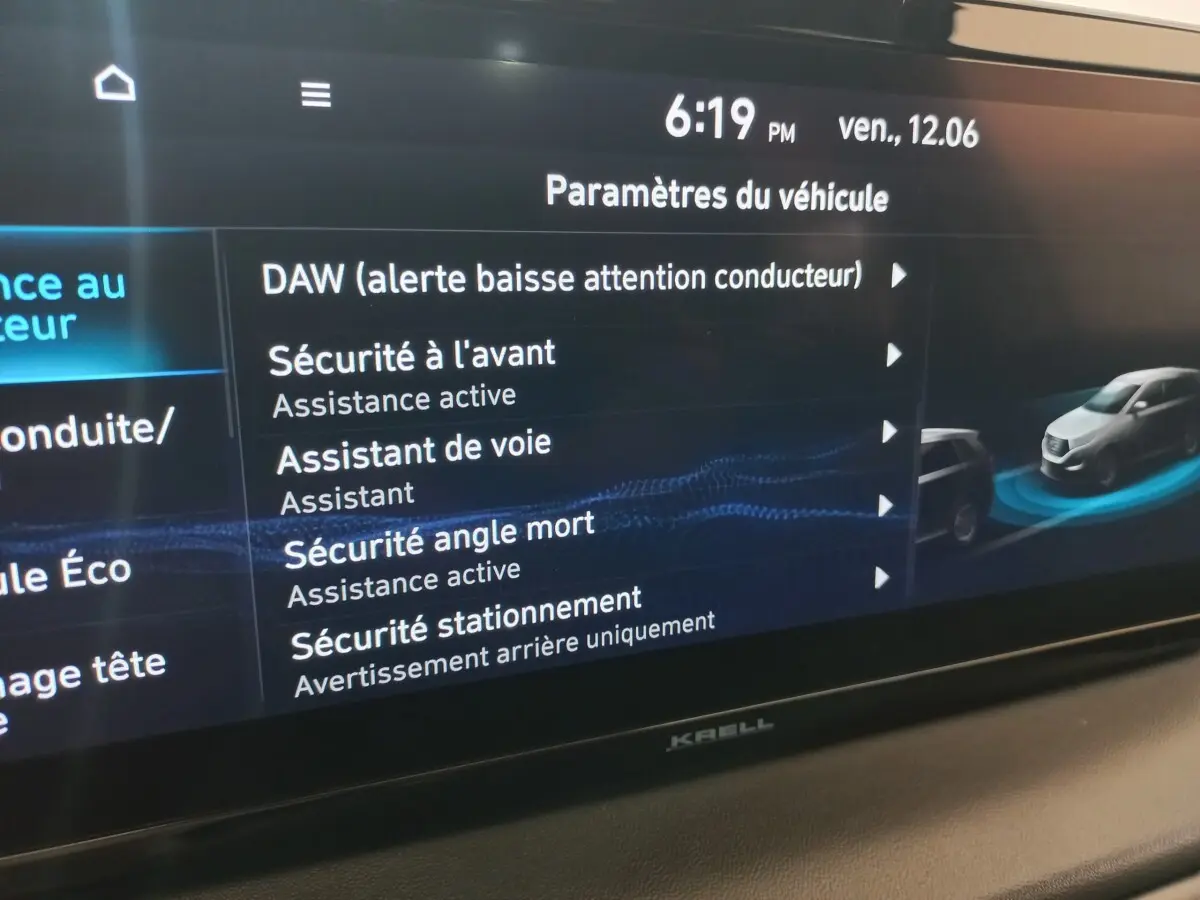 Écran tactile intérieur affichant les paramètres de sécurité du Hyundai Santa Fe hybride gris clair, vue rapprochée du tableau de bord.