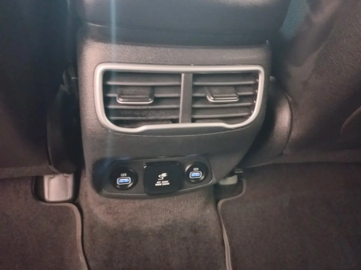Vue rapprochée des aérateurs arrière et des prises USB bleues du Hyundai Santa Fe hybride rechargeable gris clair.