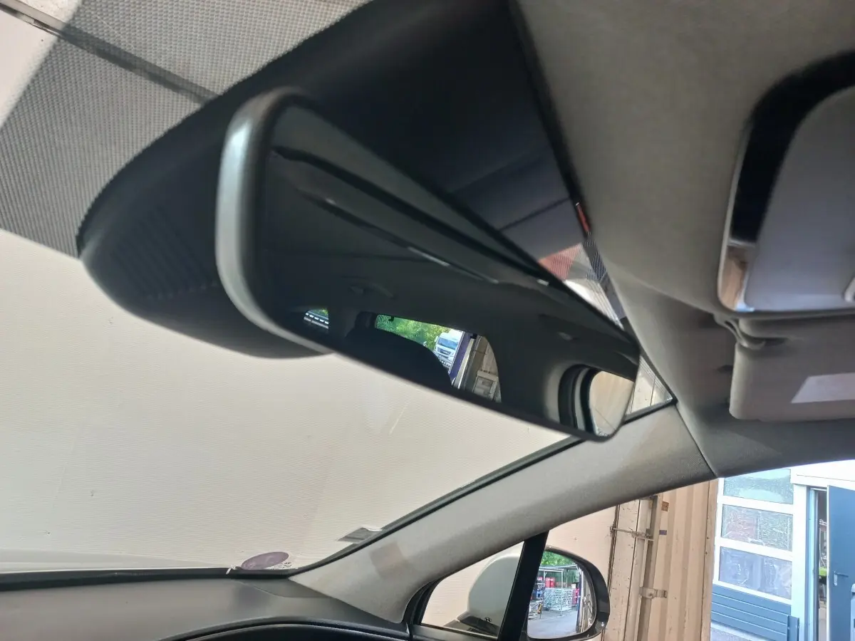 Vue intérieure du rétroviseur central du Hyundai Santa Fe gris clair 2021, avec reflet du toit et siège arrière.