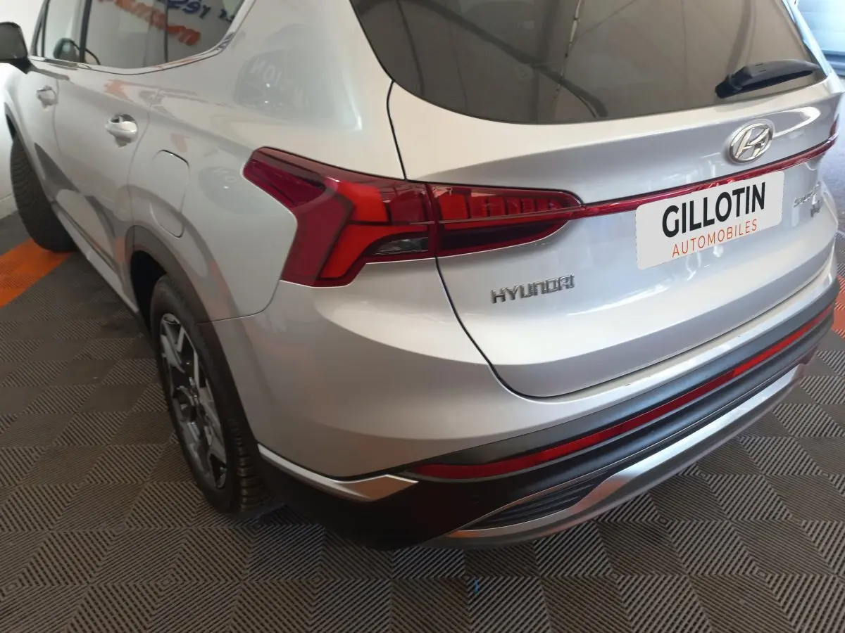 Vue 3/4 arrière droite du Hyundai Santa Fe gris clair avec feux arrière LED et jantes alliage visibles.