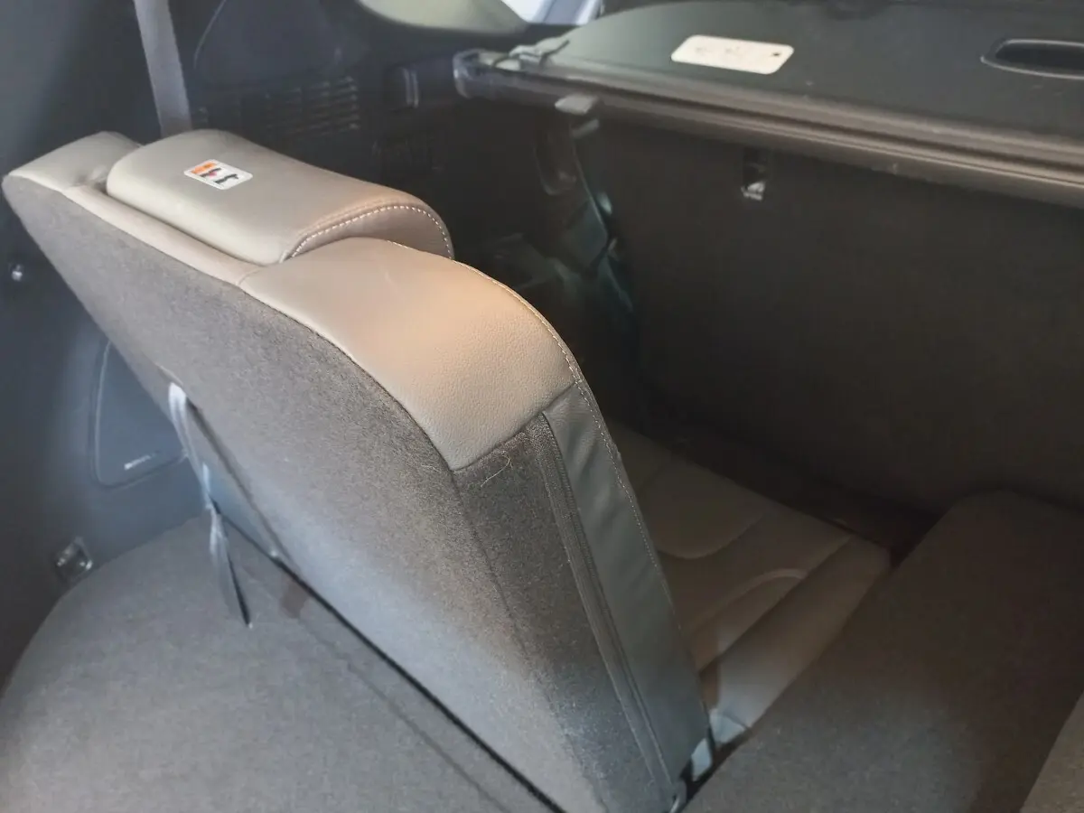 Vue rapprochée de la troisième rangée de sièges rabattus en cuir gris dans le coffre du Hyundai Santa Fe hybride 2021.