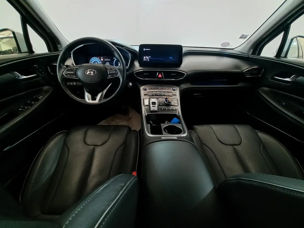 Vue intérieure avant du Hyundai Santa Fe 2021, tableau de bord et sièges en cuir noir avec écran tactile central.