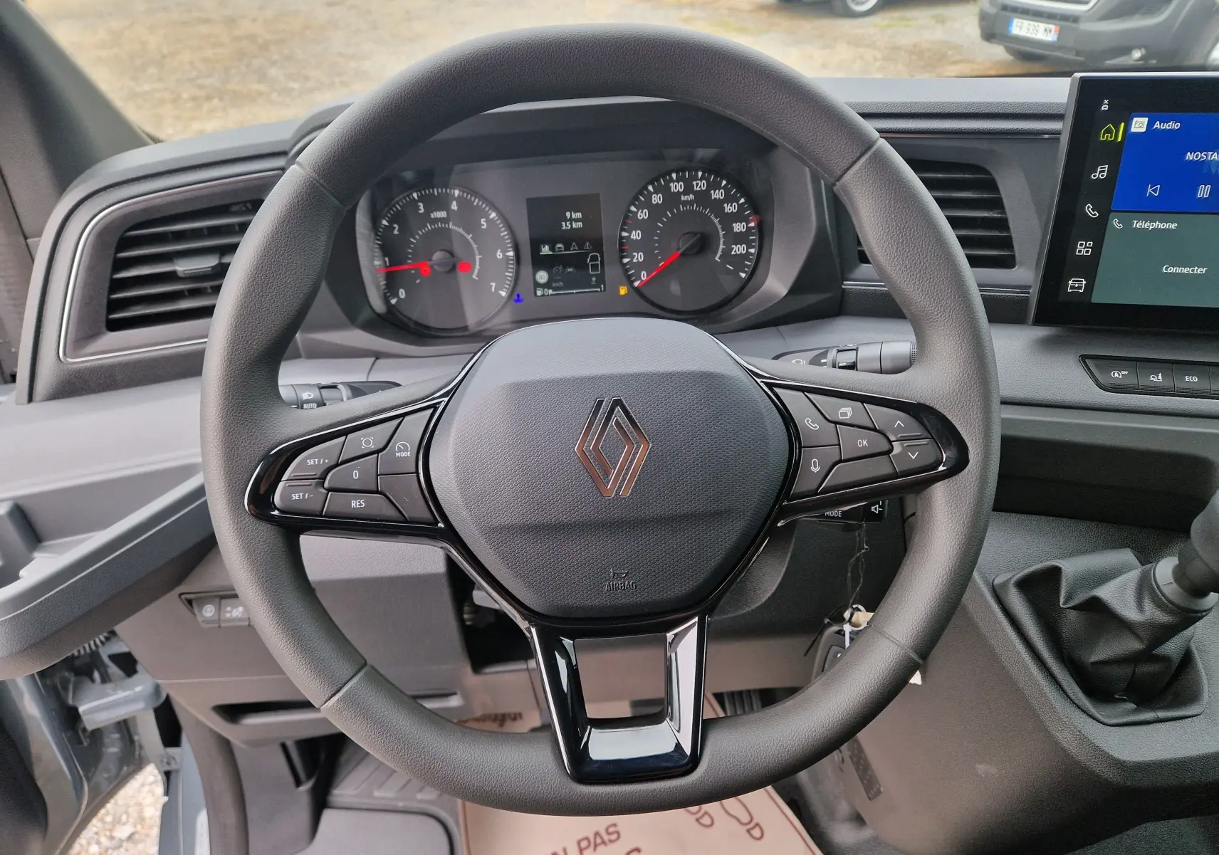 Vue rapprochée du volant multifonction gris du Renault Master 2026 avec tableau de bord et écran tactile visible.