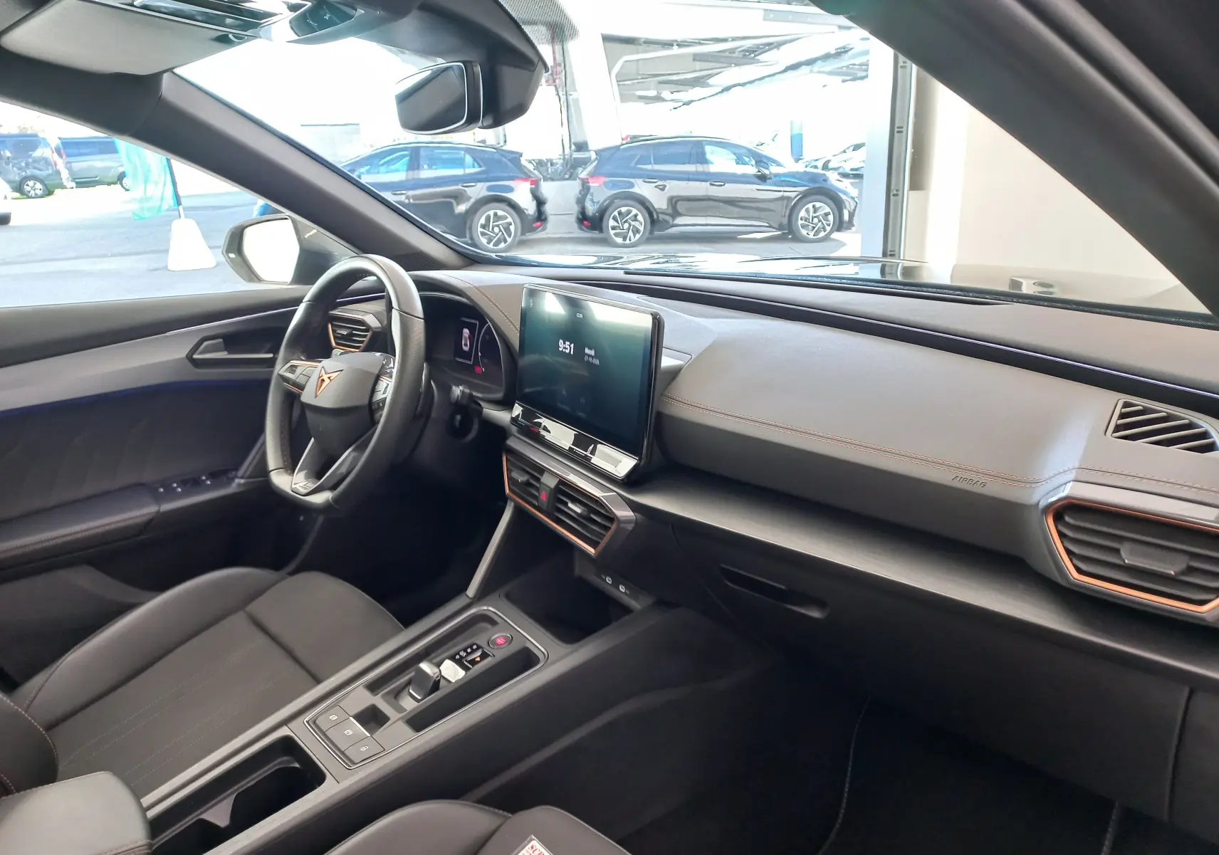 Vue intérieure côté conducteur de la CUPRA Formentor 1.4 e-HYBRID 2024 avec tableau de bord noir et écran tactile central.