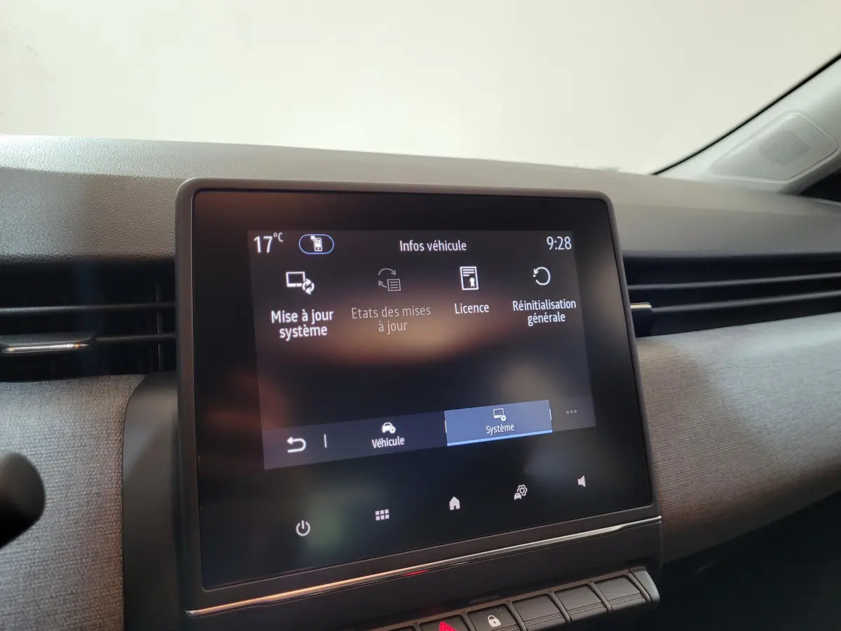 Écran tactile central affichant les options de mise à jour système dans l'habitacle d'une Renault Clio gris foncé 2025.