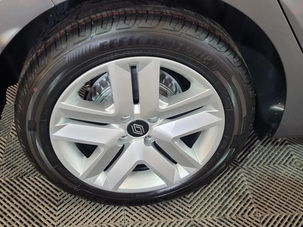Gros plan sur la roue arrière droite d'une Renault Clio gris foncé, montrant le pneu et l'aile du véhicule.