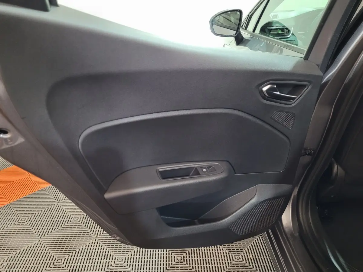 Gros plan sur la porte arrière droite grise foncée de la Renault Clio Evolution Blue dCi 100, avec commande de vitre électrique.