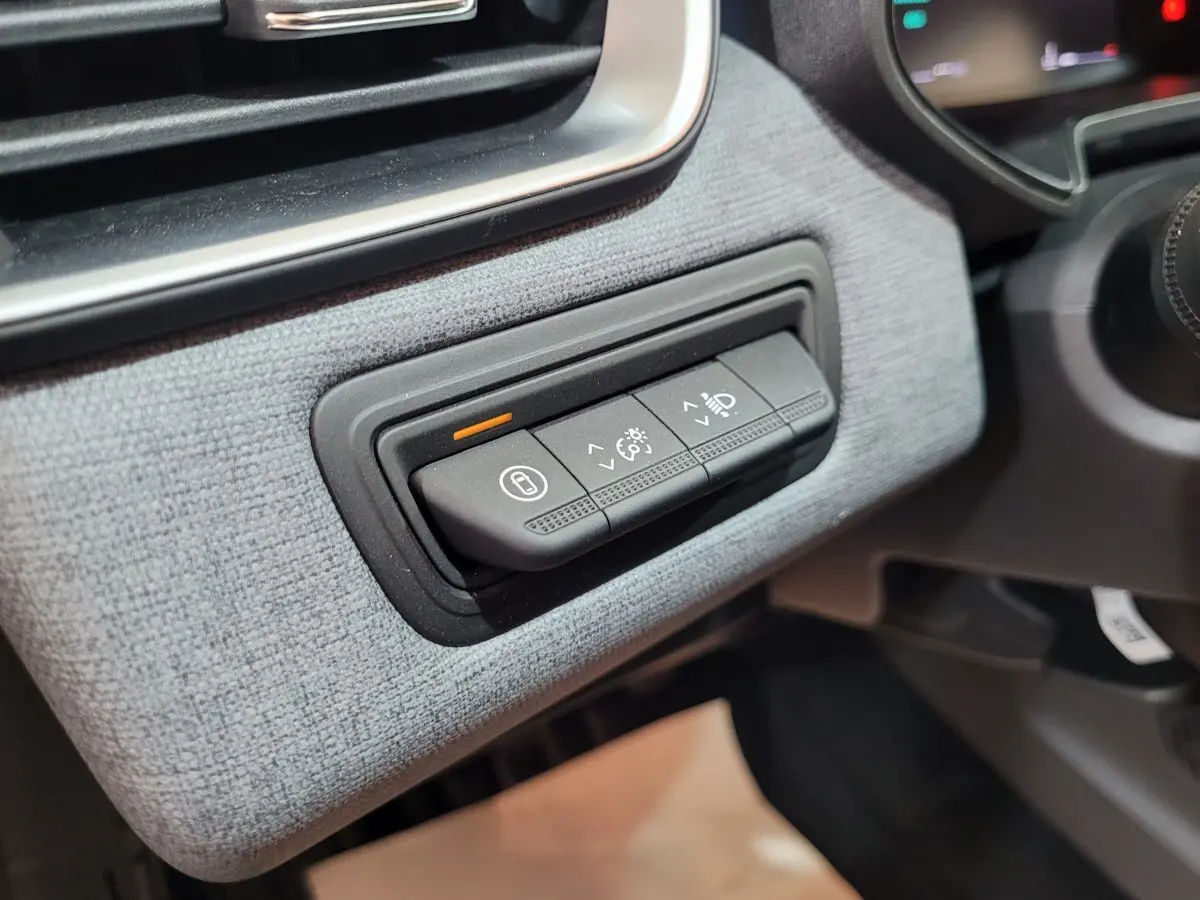 Gros plan sur les commandes d'éclairage et tableau de bord en tissu gris clair de la Renault Clio Evolution Blue dCi 100 2025.