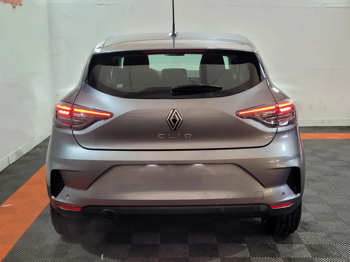 Vue arrière d'une Renault Clio gris foncé 2025 avec feux LED allumés dans un garage.