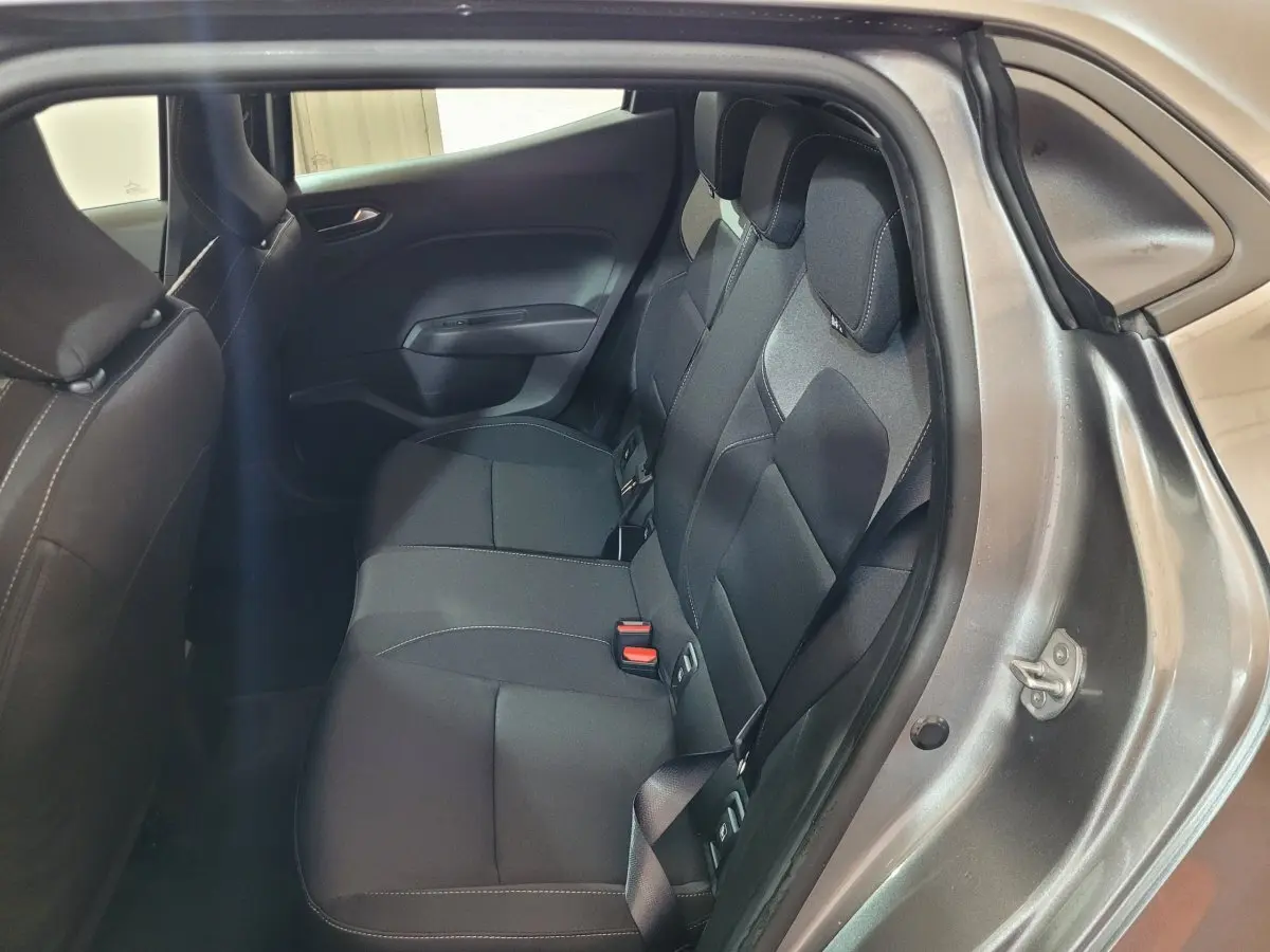 Vue intérieure sur la banquette arrière noire de la Renault Clio gris foncé Evolution Blue dCi 2025, porte ouverte côté droit.