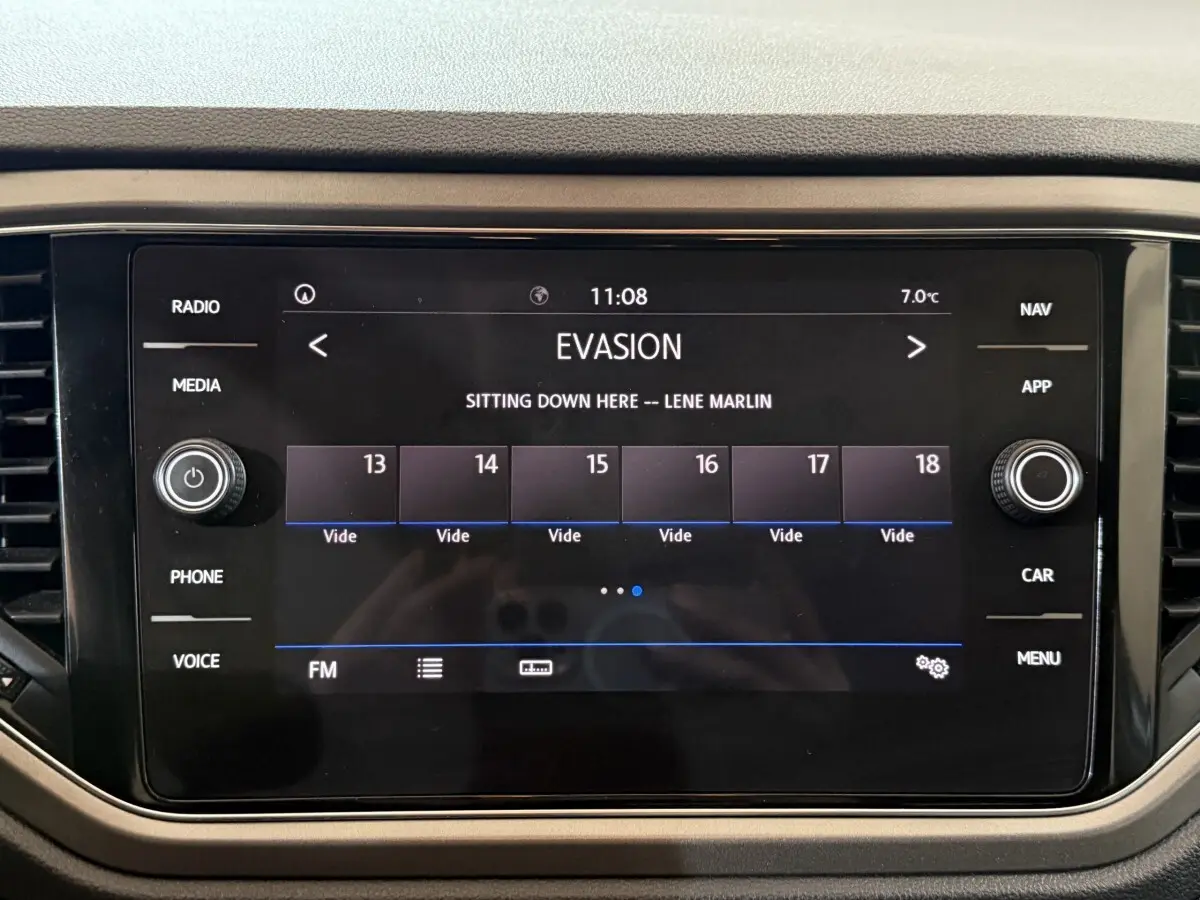 Écran tactile central du tableau de bord du Volkswagen T-Roc noir, affichant une station radio FM à 11h08.