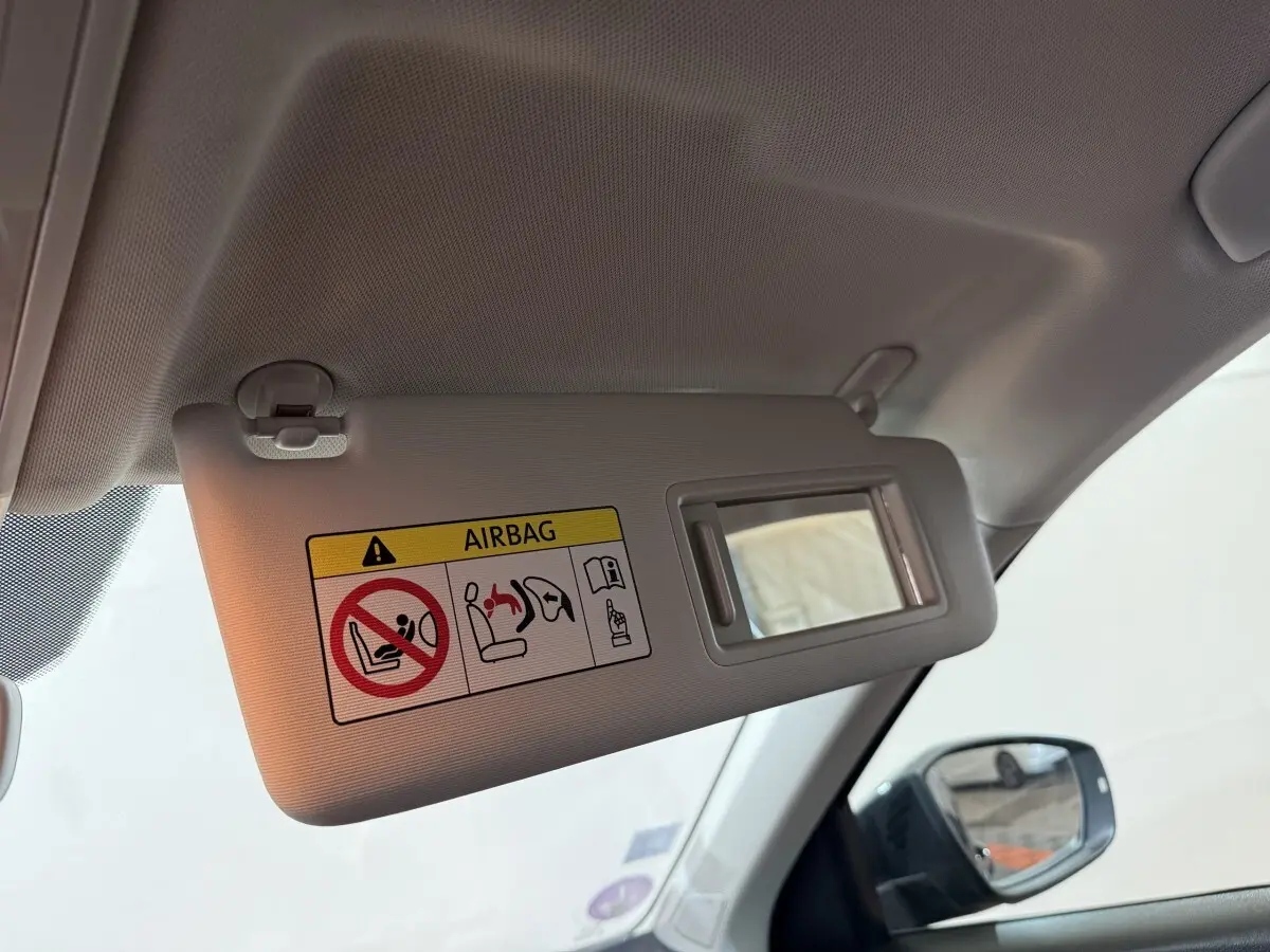 Détail du pare-soleil côté conducteur avec miroir et avertissement airbag dans un Volkswagen T-Roc noir 2020.