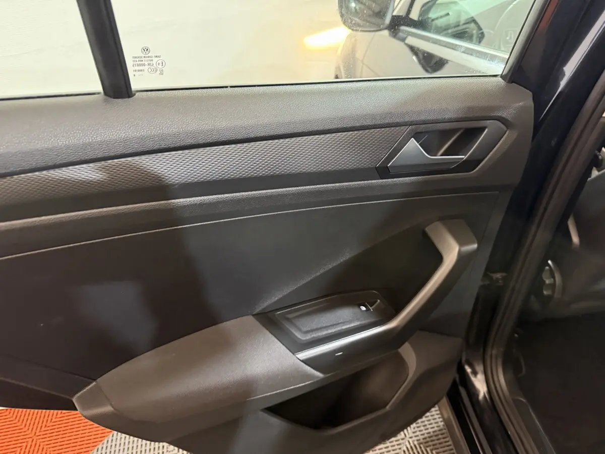 Gros plan sur la porte arrière gauche noire du Volkswagen T-Roc 2020, avec poignée et commande de fenêtre visible.