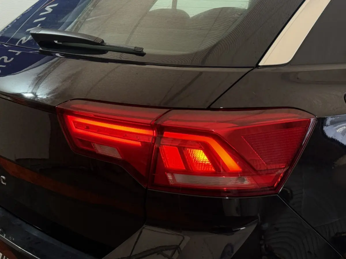 Feu arrière droit allumé d'un Volkswagen T-Roc noir 2020, vue rapprochée sur la partie arrière côté droit.