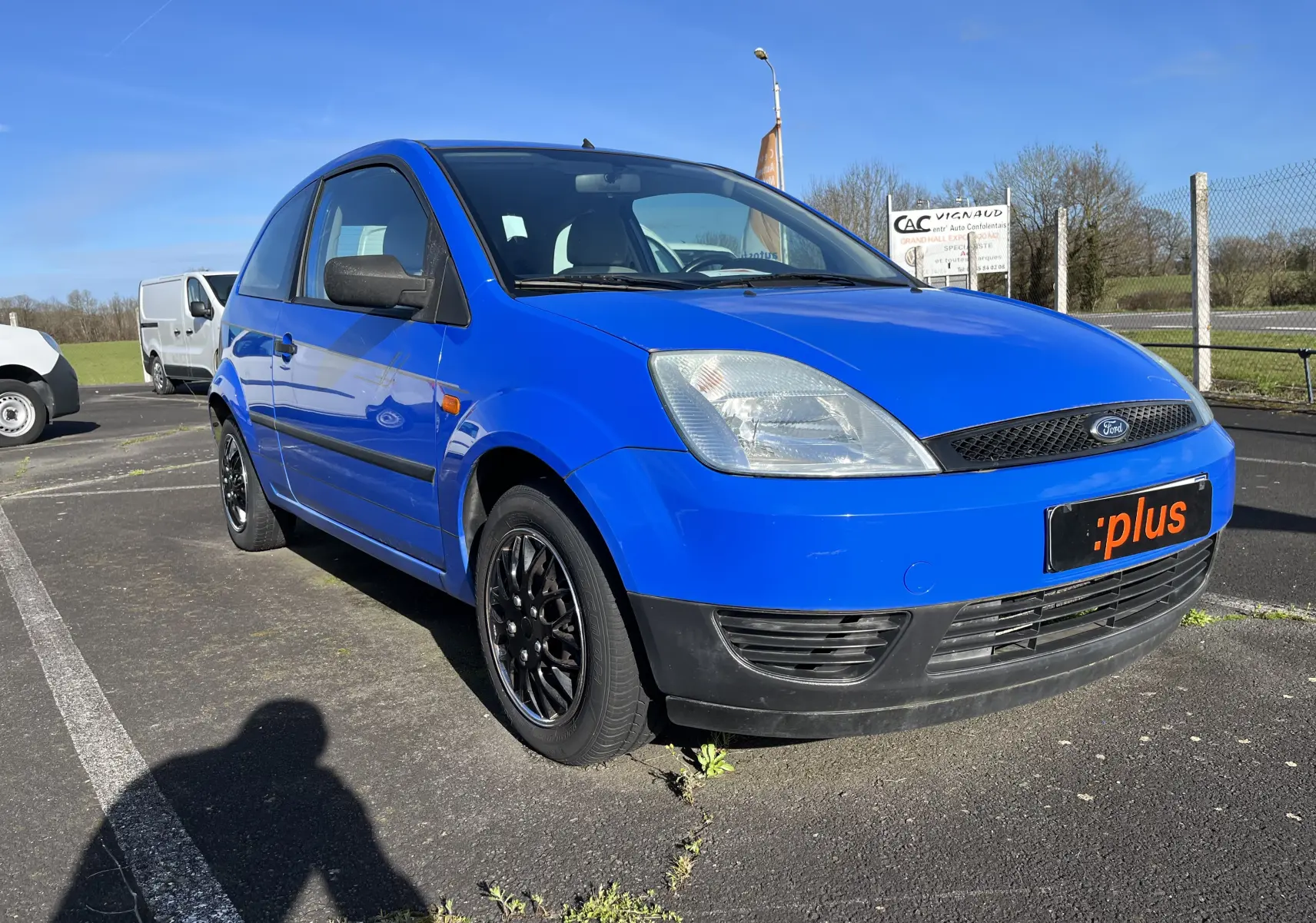 Ford Fiesta 2003 bleu vue 3/4 avant droit, compacte 3 portes avec jantes noires sur parking extérieur.