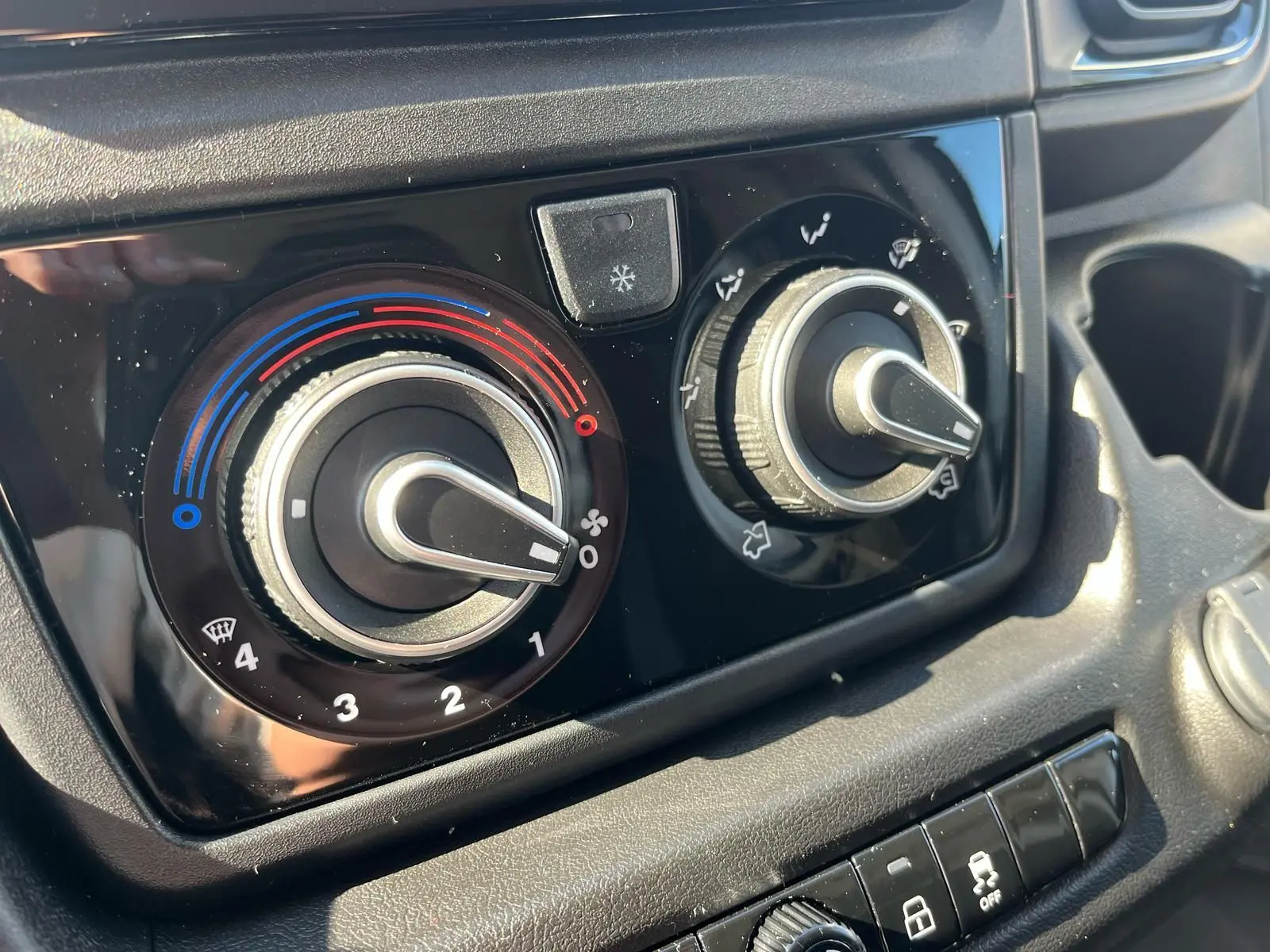 Gros plan sur les commandes de climatisation du Fiat Ducato Fourgon blanc 2023, avec réglages de température et ventilation.