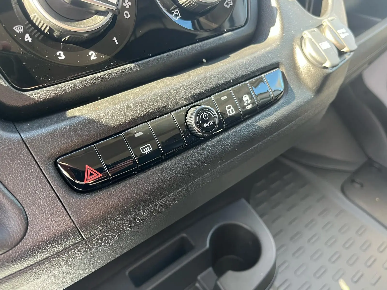 Gros plan sur la rangée de boutons noirs du tableau de bord du Fiat Ducato Fourgon blanc, 2023.