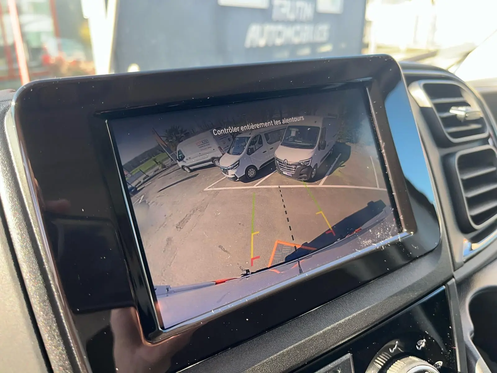 Écran de caméra de recul dans un Fiat Ducato blanc, vue arrière avec marquages de guidage colorés.
