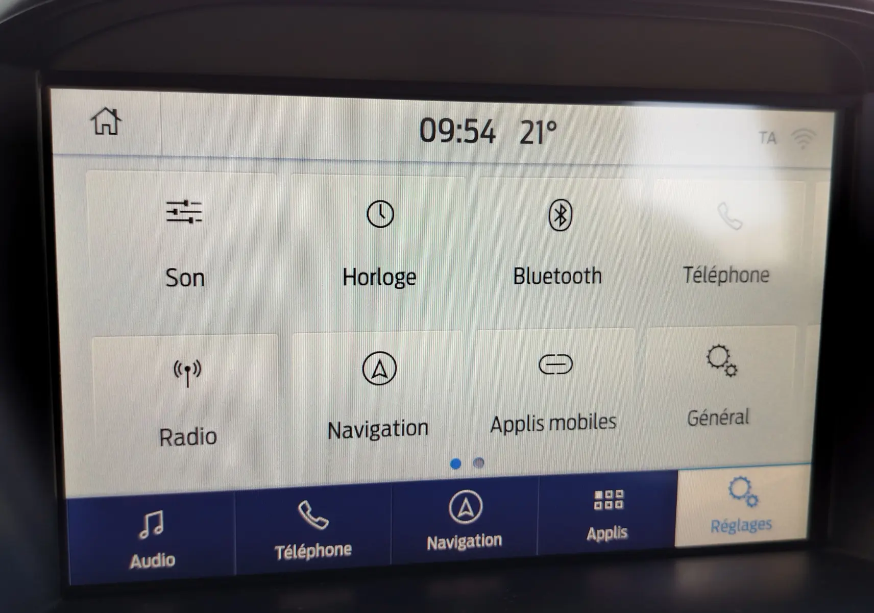 Écran tactile central du Ford Kuga 2019 affichant les options audio, téléphone, navigation et réglages dans un intérieur gris.