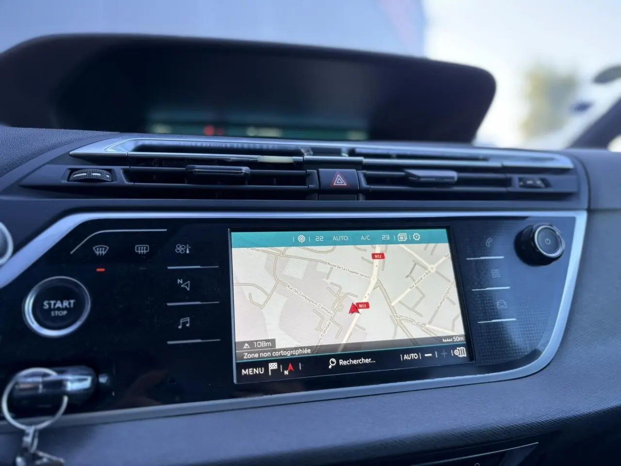 Tableau de bord de Citroën C4 Picasso gris Platinium de 2017 avec écran tactile GPS affichant une carte en navigation.