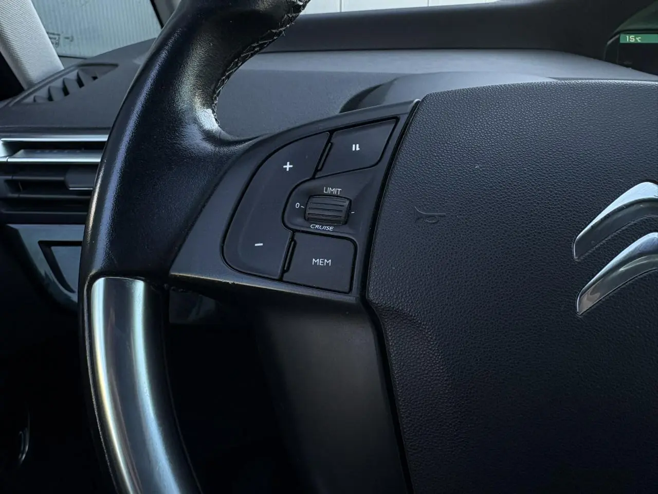 Gros plan sur le volant cuir noir de la Citroën C4 Picasso 2017 avec commandes de régulateur de vitesse côté gauche.