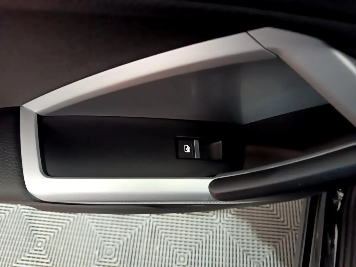 Bouton de verrouillage des portes sur la poignée intérieure côté gauche d'un Audi Q3 noir 2020 Business Line.