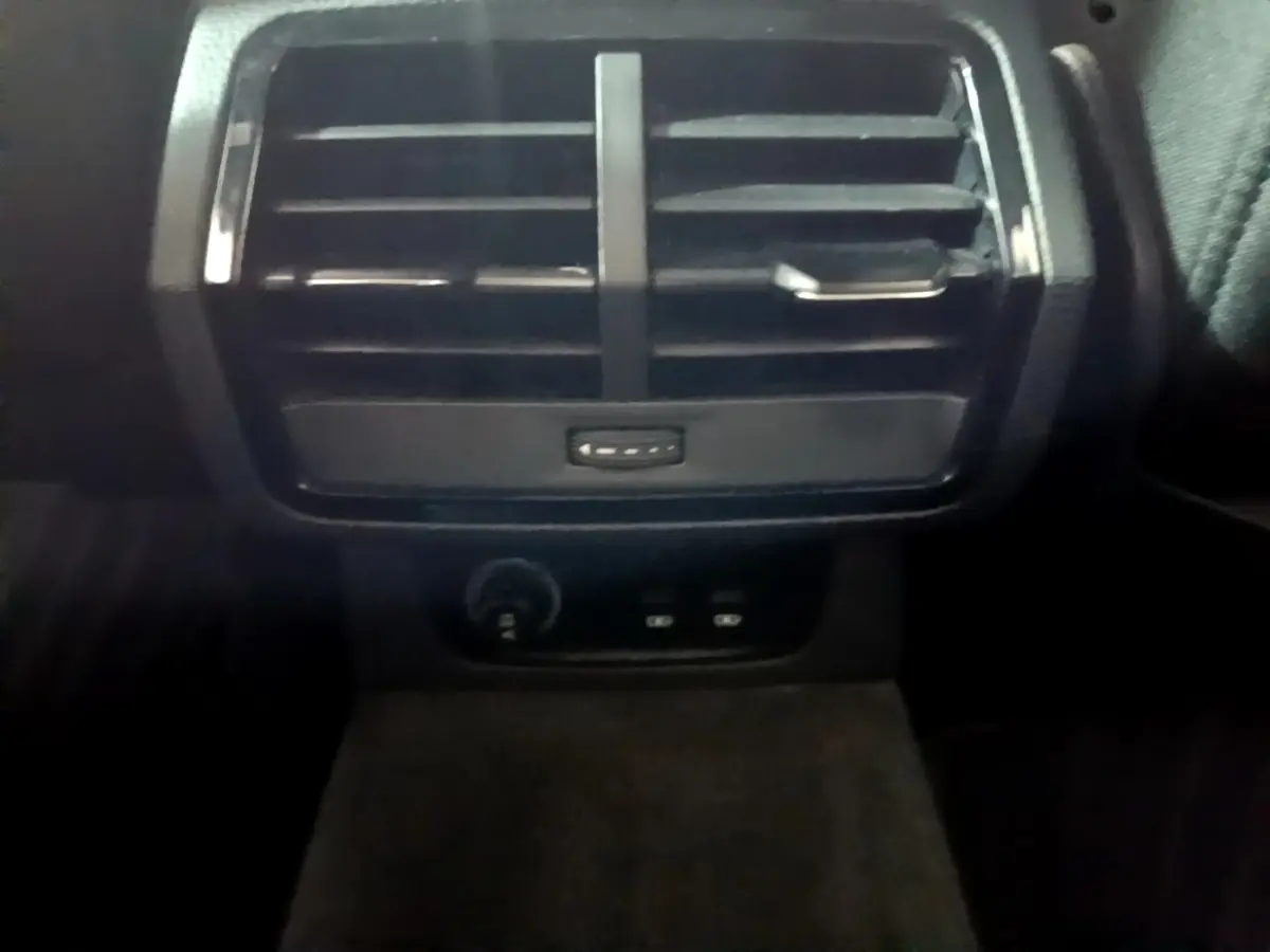 Gros plan sur la sortie d'air arrière noire et les commandes de charge USB du coffre de l'Audi Q3 35 TDI 2020.