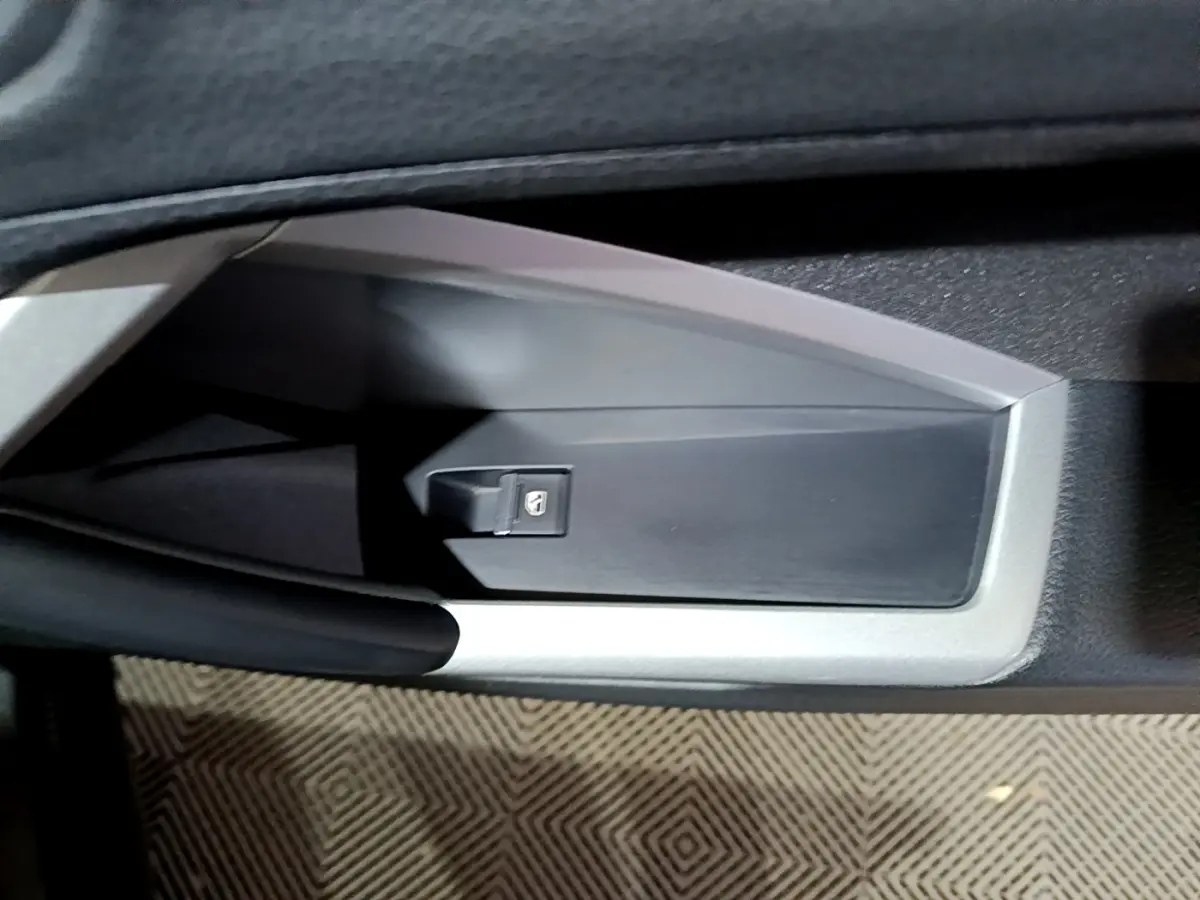 Détail de la commande de lève-vitre côté conducteur sur la porte intérieure d’un Audi Q3 noir 2020.