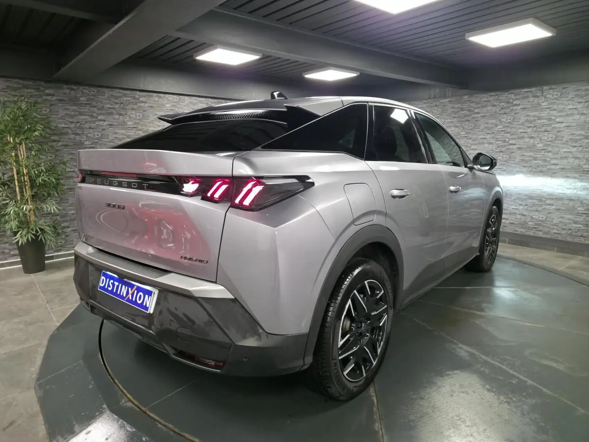 Vue 3/4 arrière droite d’un Peugeot 3008 gris métallisé avec feux arrière LED en forme de griffes et jantes alliage noires.