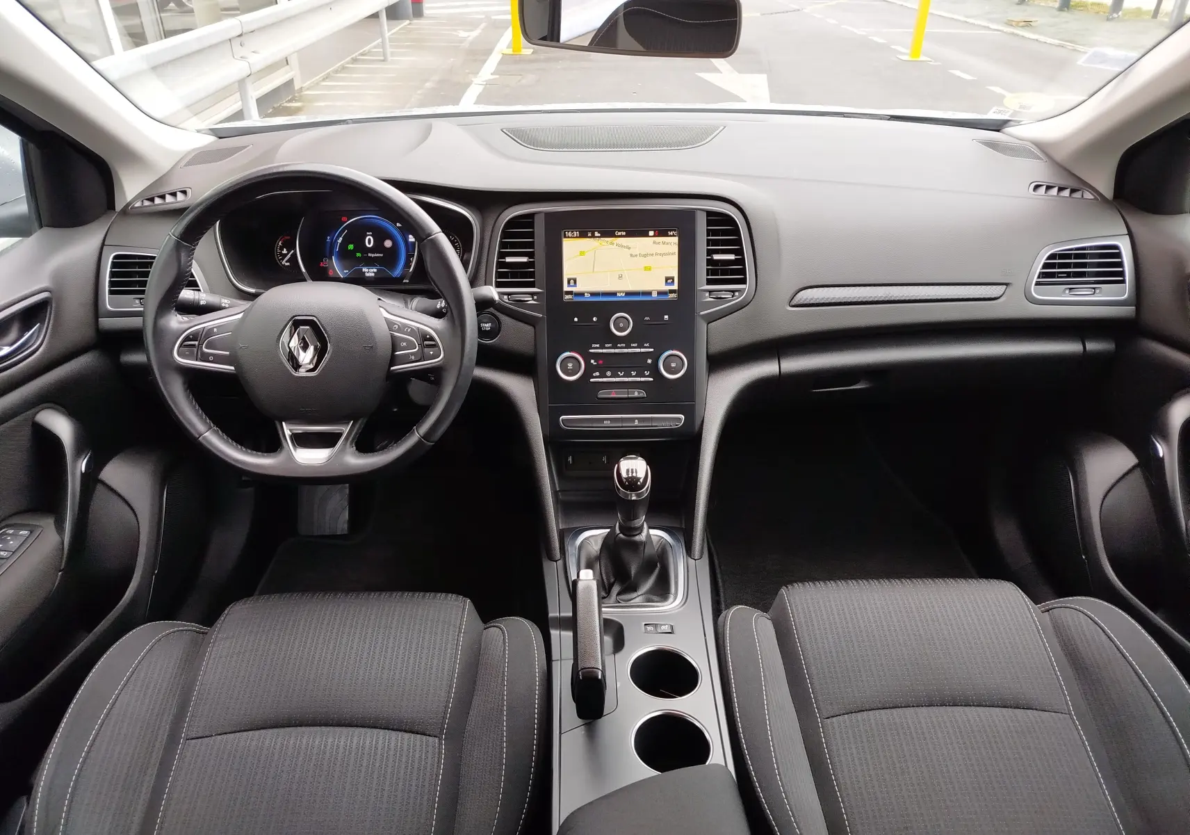 Vue intérieure avant de la Renault Mégane 1.5 dCi 110ch Business 2018, tableau de bord avec écran tactile et volant multifonction.