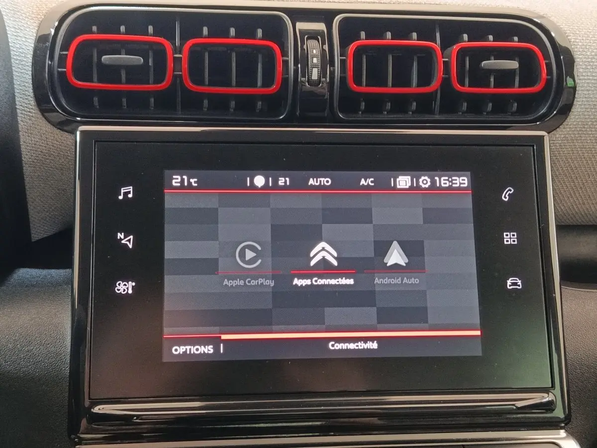 Vue rapprochée de la console centrale noire avec écran tactile et aérateurs rectangulaires du Citroën C3 Aircross beige.