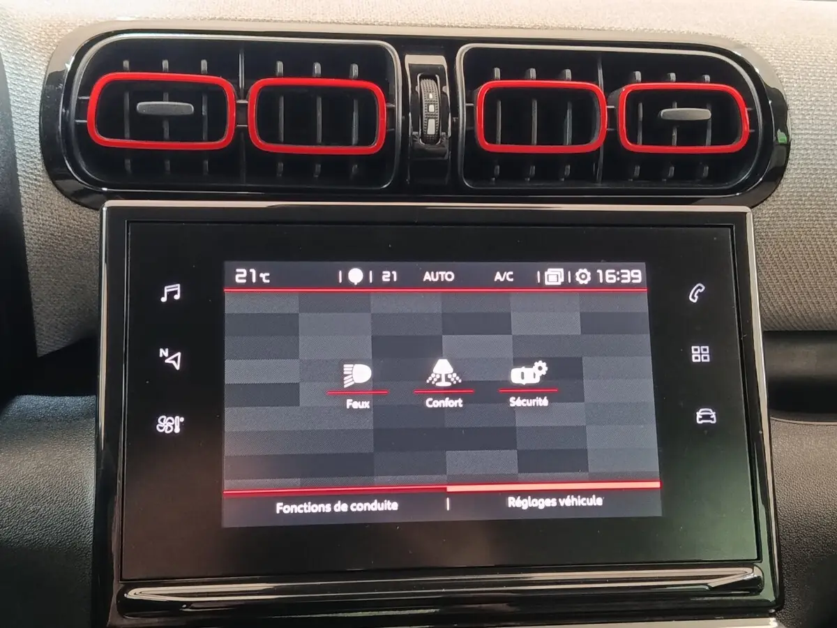 Écran tactile central et aérateurs rectangulaires noirs avec contours rouges dans le tableau de bord d'une Citroën C3 Aircross beige.