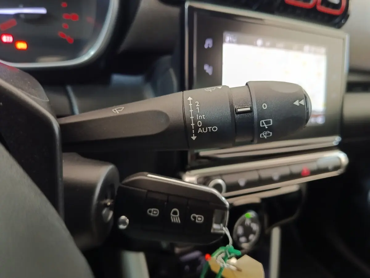 Gros plan sur la commande d’essuie-glace et la clé de contact dans l’habitacle beige du Citroën C3 Aircross 2021.