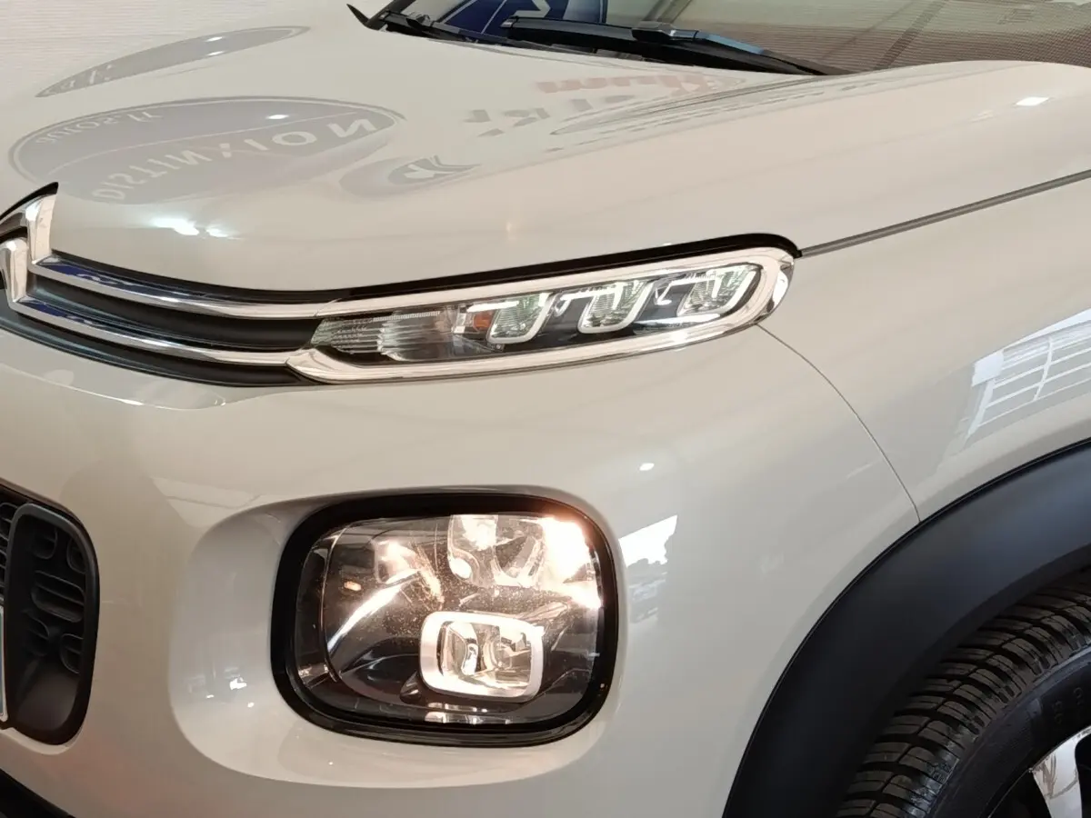 Gros plan sur l'avant droit beige du Citroën C3 Aircross avec ses phares LED distinctifs et la calandre chromée.