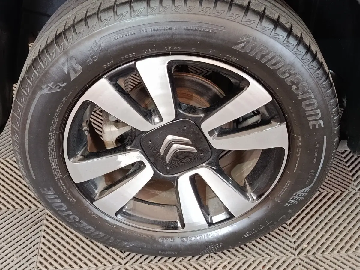 Gros plan sur la jante alliage bicolore et le pneu Bridgestone d’un Citroën C3 Aircross beige.