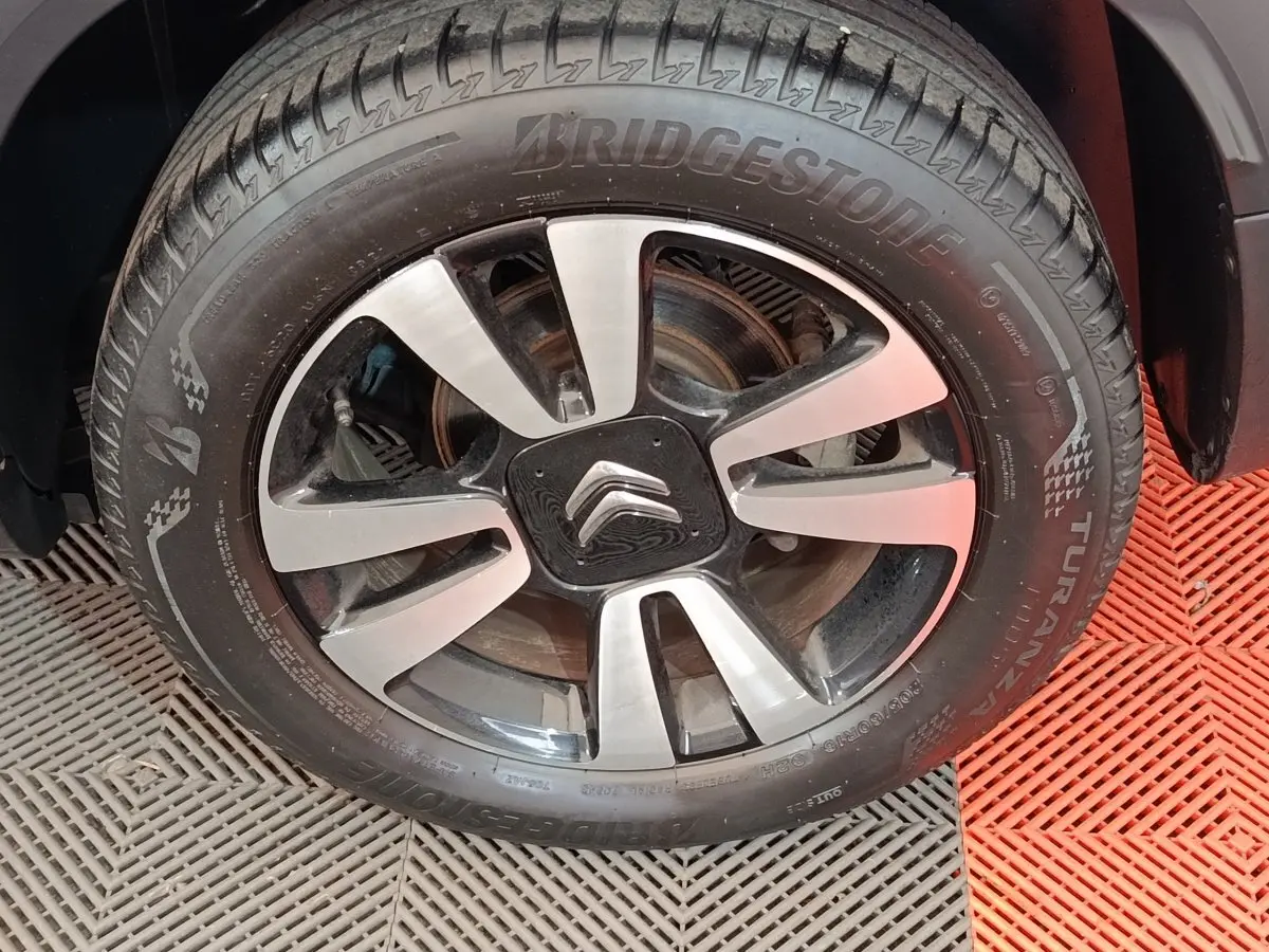 Gros plan sur la roue avant droite du Citroën C3 Aircross beige, avec jante alliage et logo Citroën au centre.