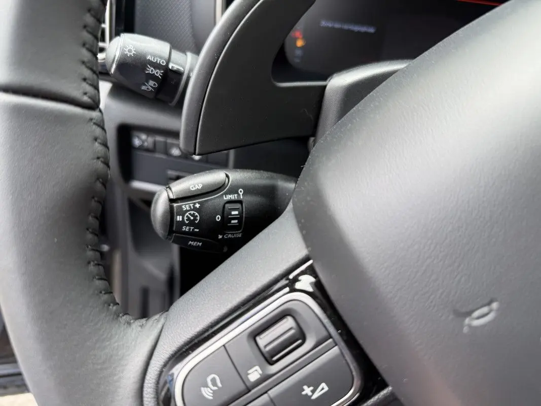 Gros plan sur le volant et la commande de régulateur de vitesse du Citroën C5 Aircross 1.5 HDi 130 gris platinium.