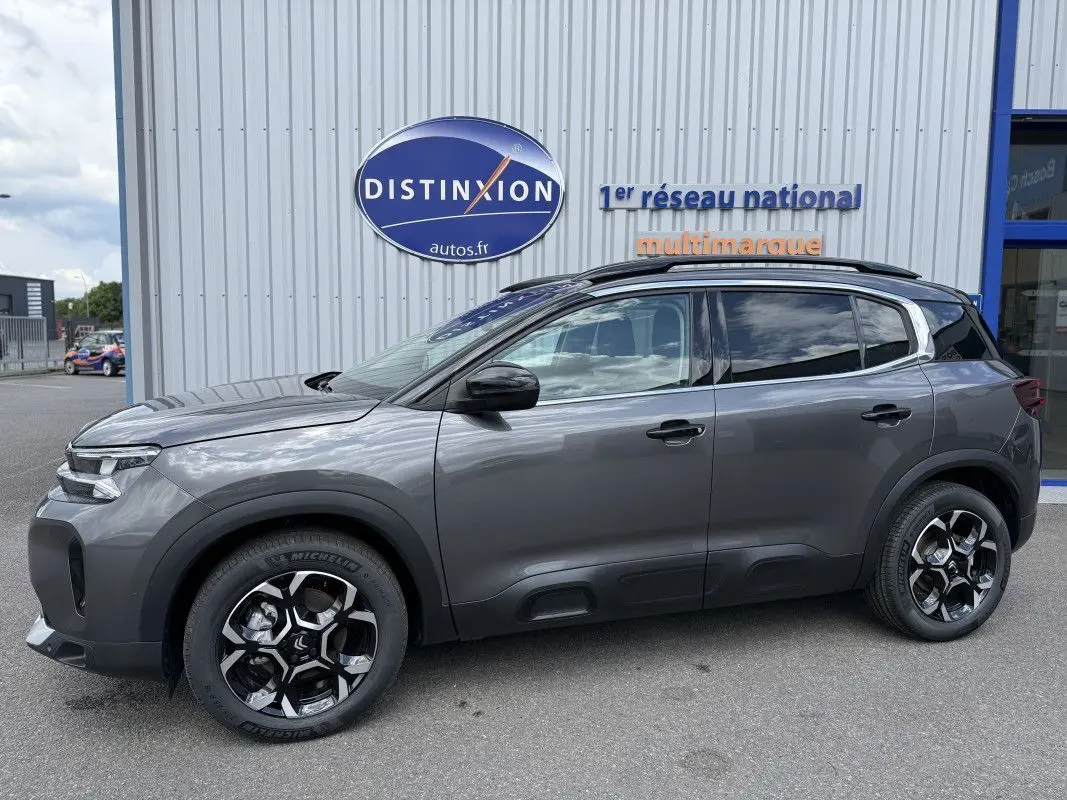 Vue de profil côté gauche d’un Citroën C5 Aircross gris platinium métallisé avec jantes noires et toit noir.