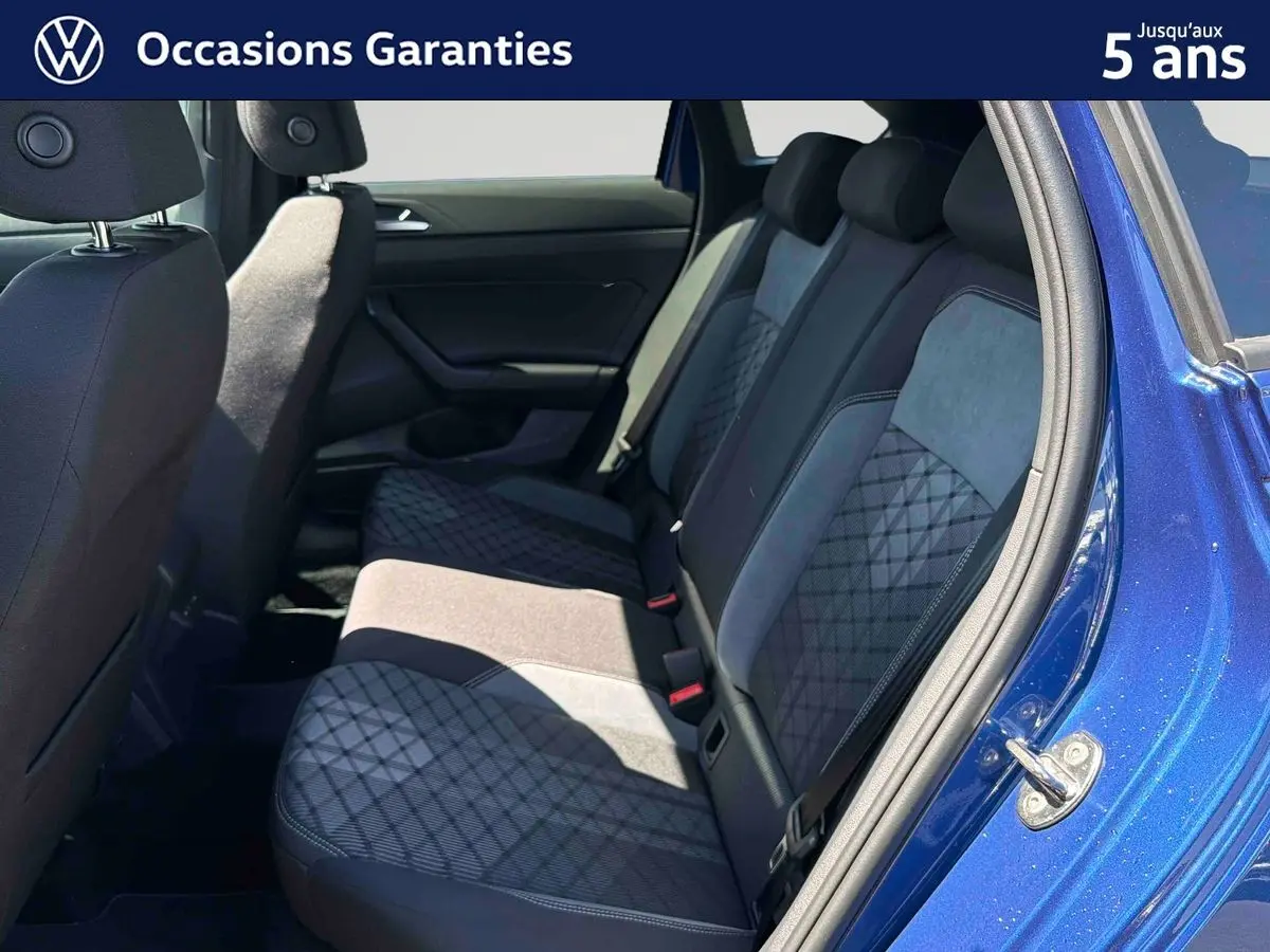 Vue intérieure côté droit sur la banquette arrière du Volkswagen Taigo bleu avec sellerie tissu à motifs géométriques.