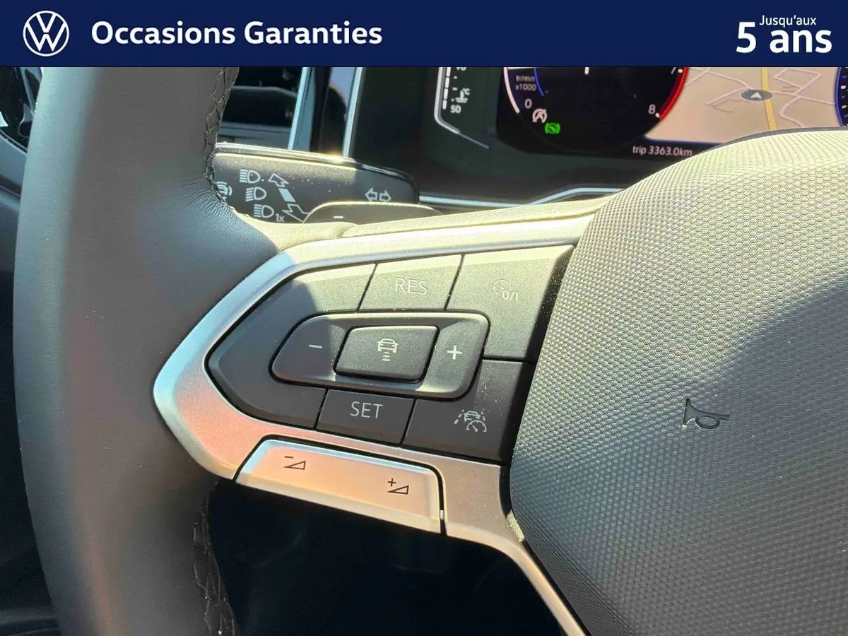 Gros plan sur le volant cuir multifonctions du Volkswagen Taigo 2025 avec commandes d’aide à la conduite intégrées.