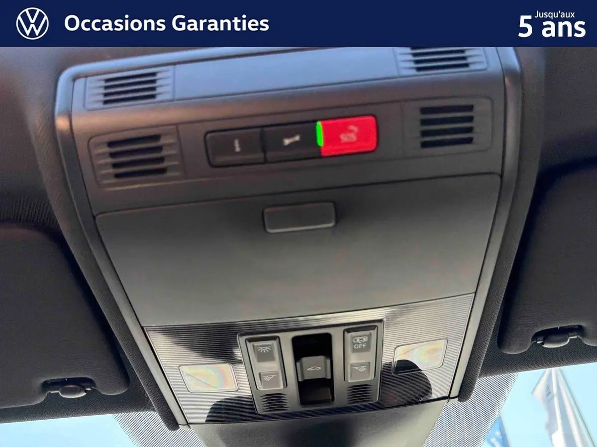 Vue en gros plan du panneau de commandes du toit ouvrant électrique en verre du Volkswagen Taigo bleu.
