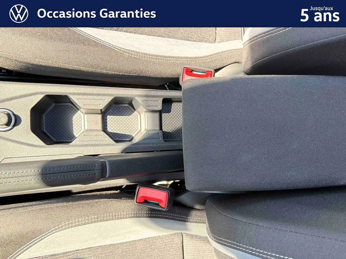Vue plongeante sur la console centrale et les sièges avant gris foncé du Volkswagen Taigo 2025.