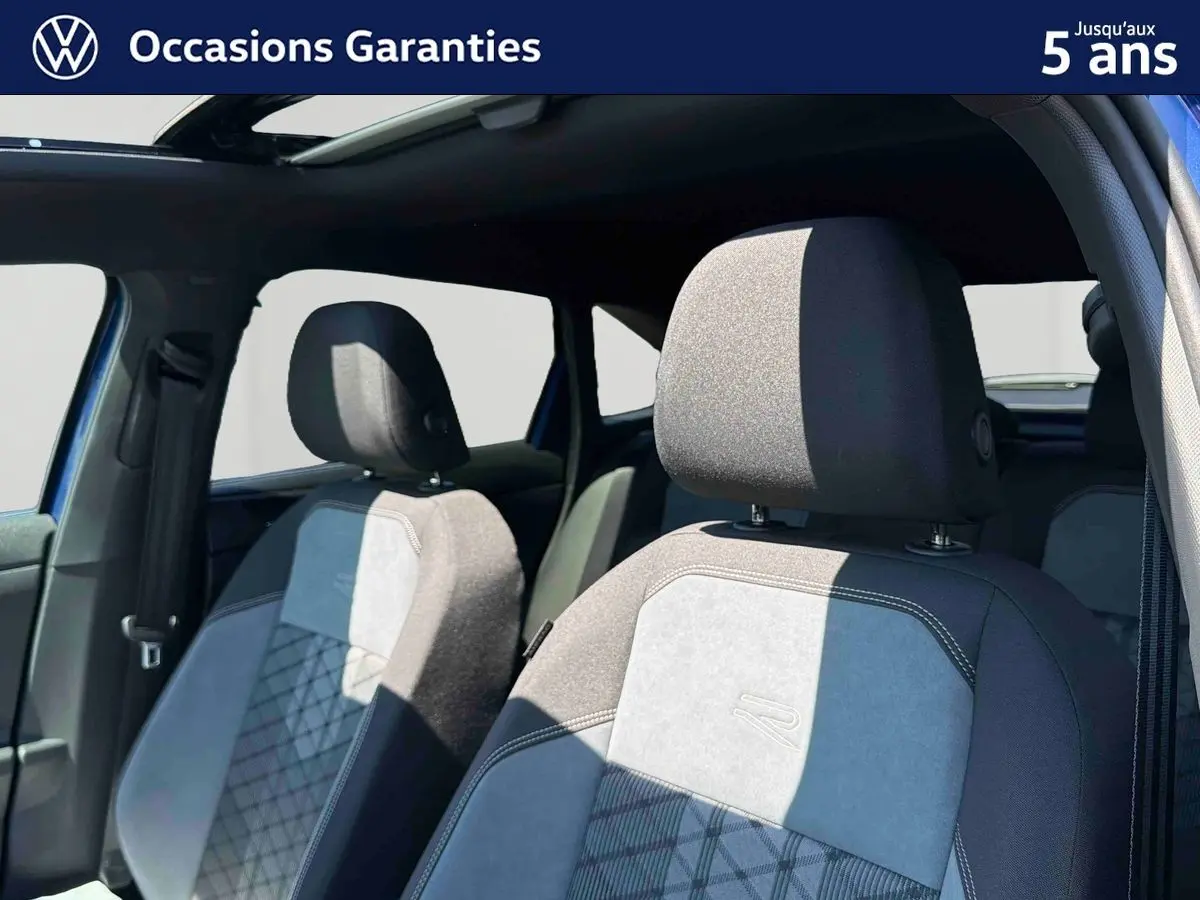 Vue intérieure sur les sièges avant gris et noirs du Volkswagen Taigo 2025 avec toit ouvrant électrique en verre.