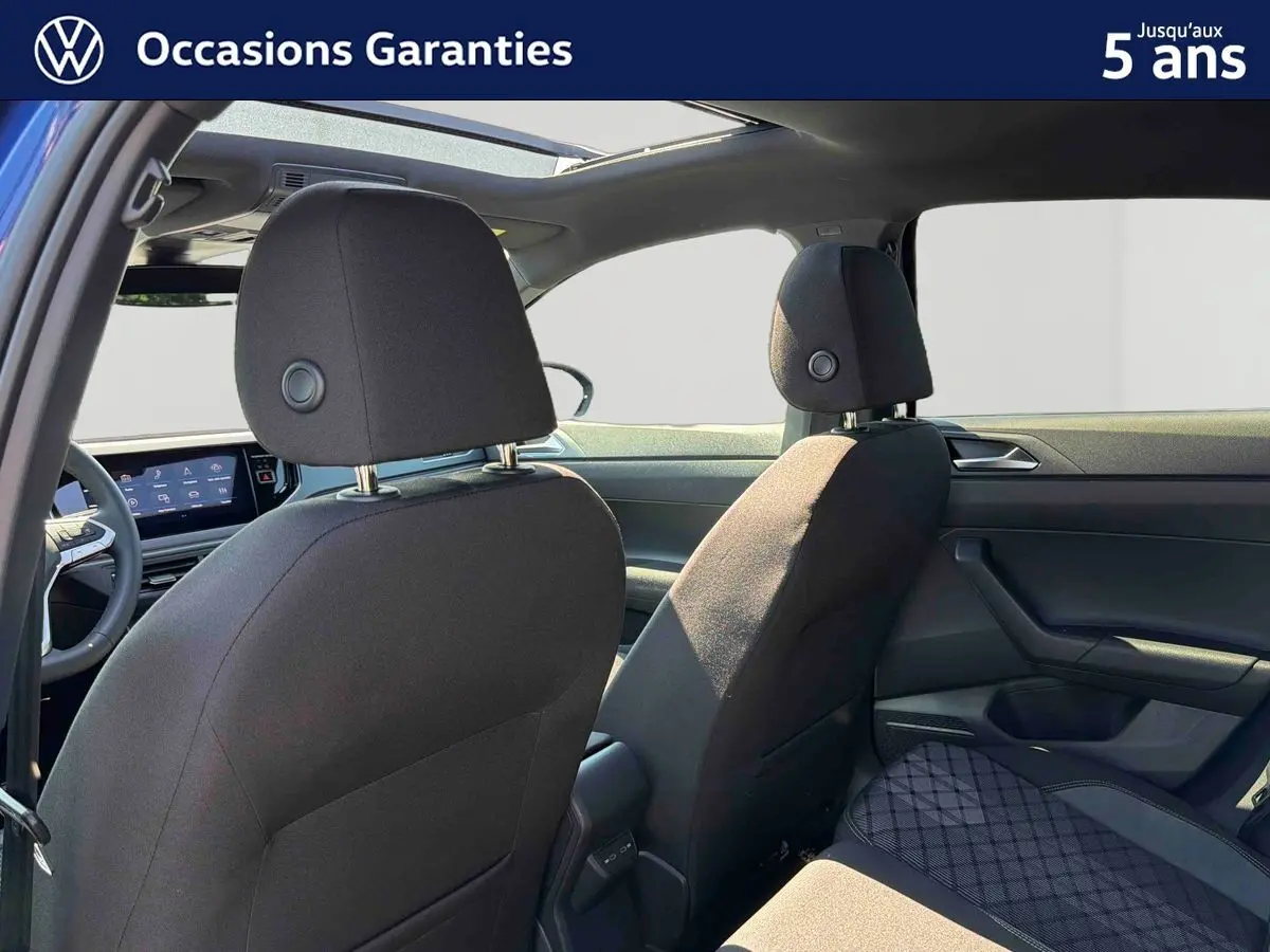 Vue intérieure arrière du Volkswagen Taigo 2025 montrant les sièges avant noirs et le toit ouvrant en verre.